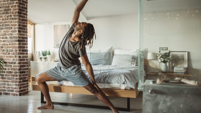 man doing yoga in his home