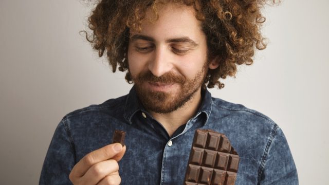Man eating squares of chocolate