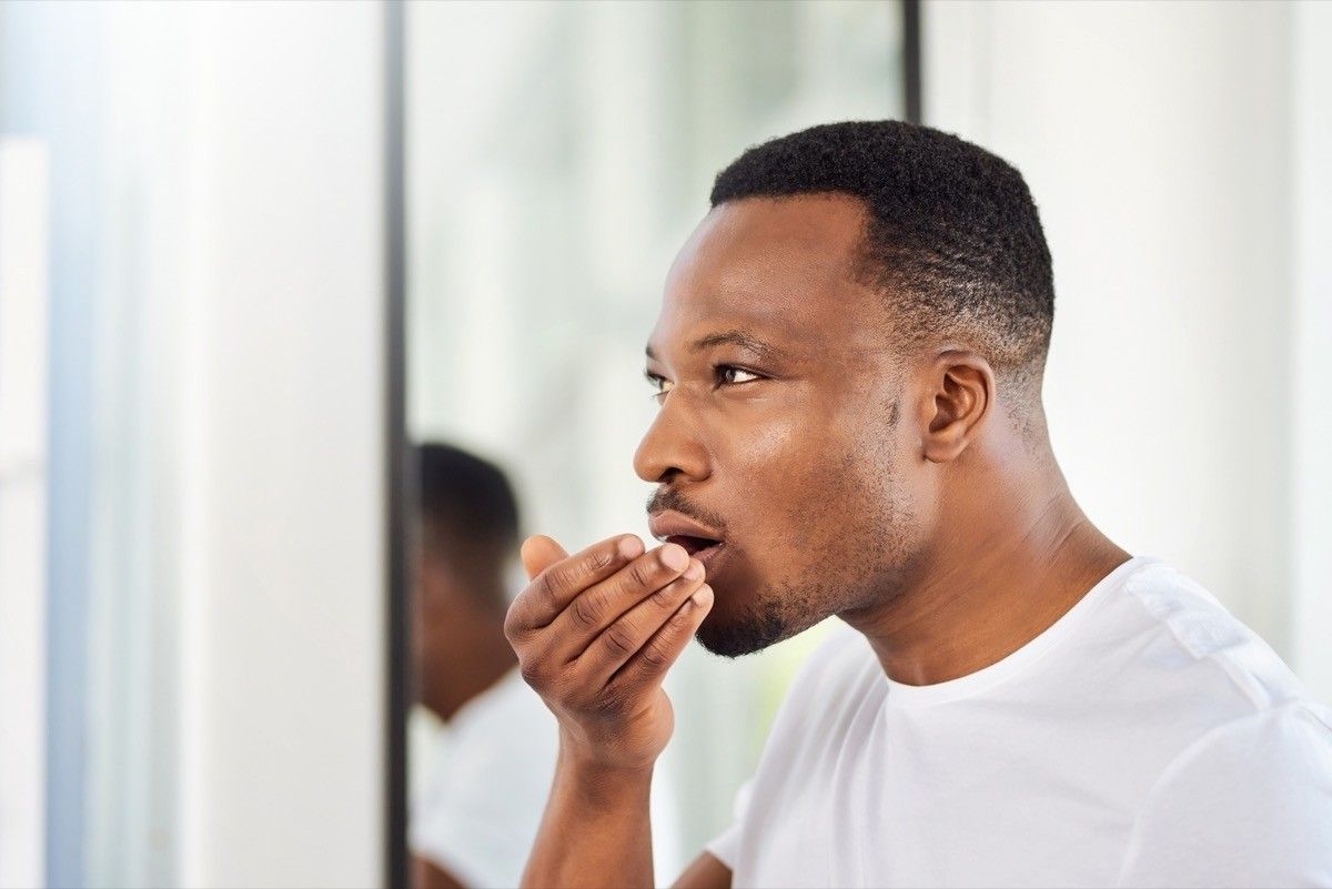 Black man smelling his breath