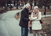 Elderly Couple in Warm Clothing Arguing in a Park During Cold Autumn Day.