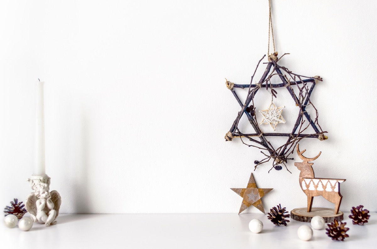 star of david made of branches and hanukkah decorations on white table