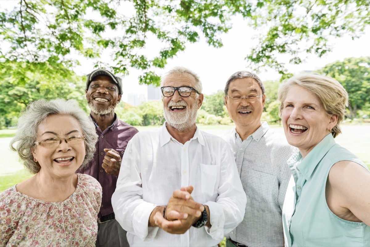Grup de oameni în vârstă zâmbind multirasiali într-un parc