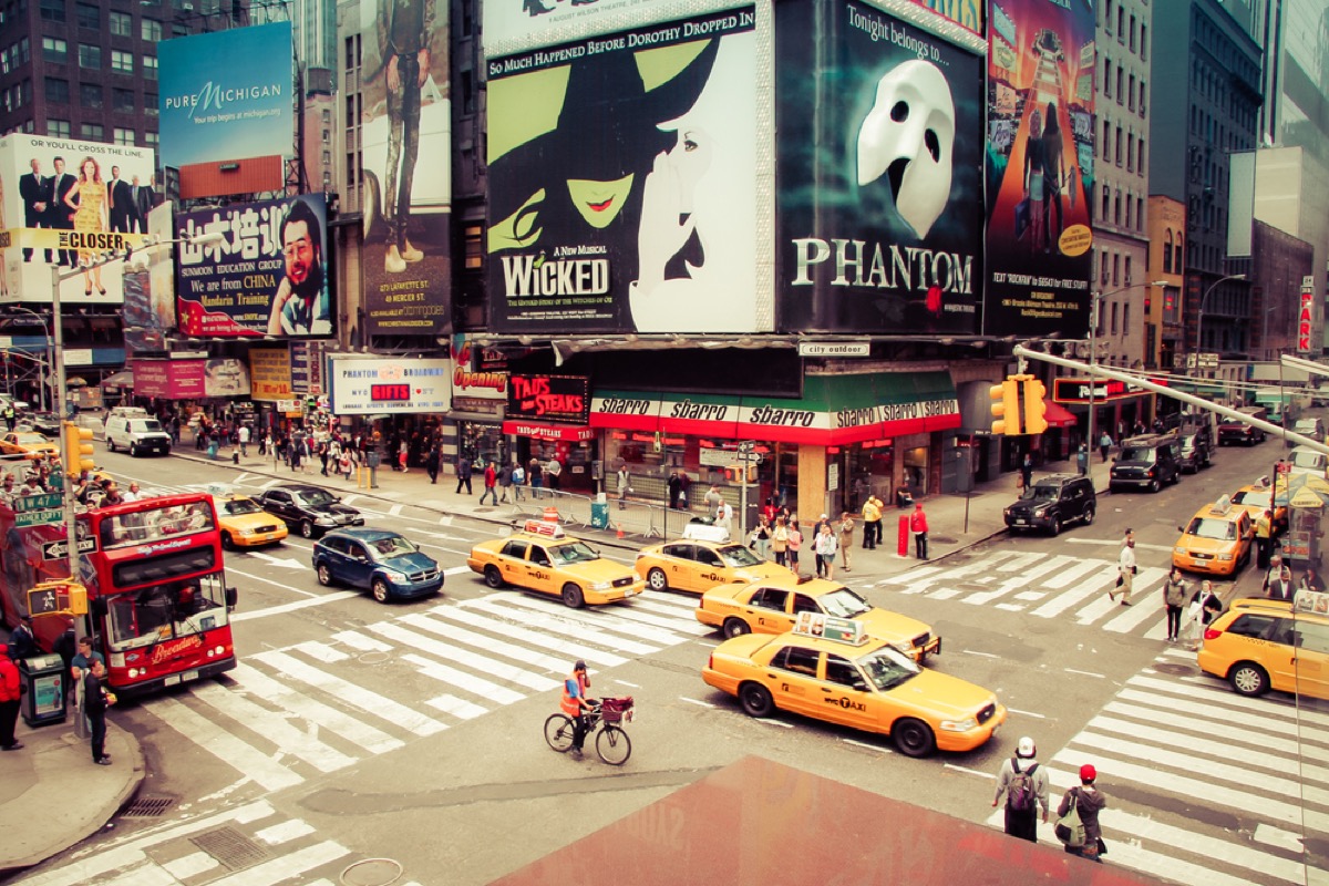 Time square in New York with yellow taxis and poster for Wicked