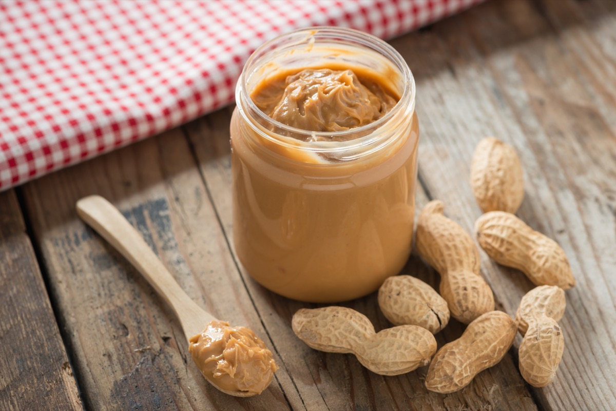 open jar of peanut butter with peanuts