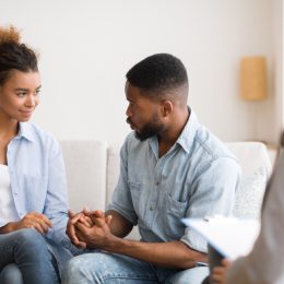 black couple holding hands at couples therapy