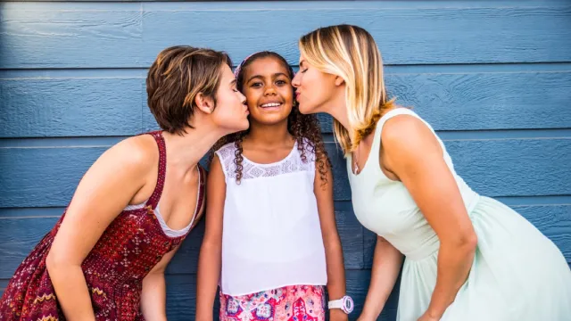 two white women kissing their daughter