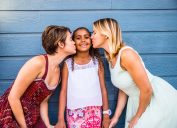 two white women kissing their daughter
