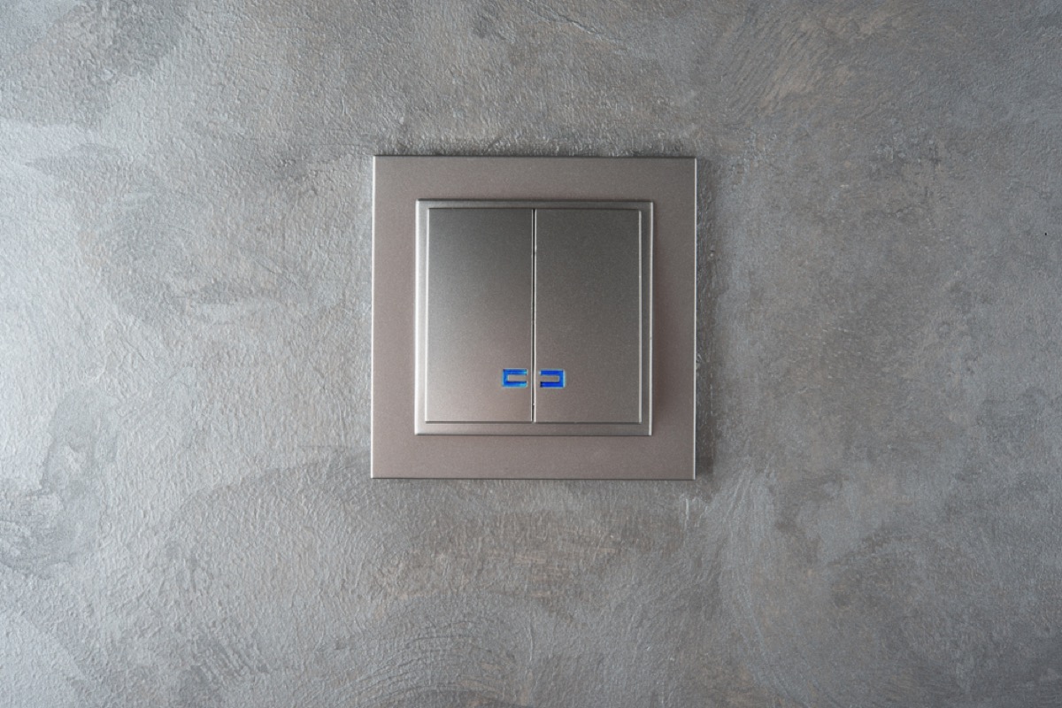 silver light switch plate on gray wall