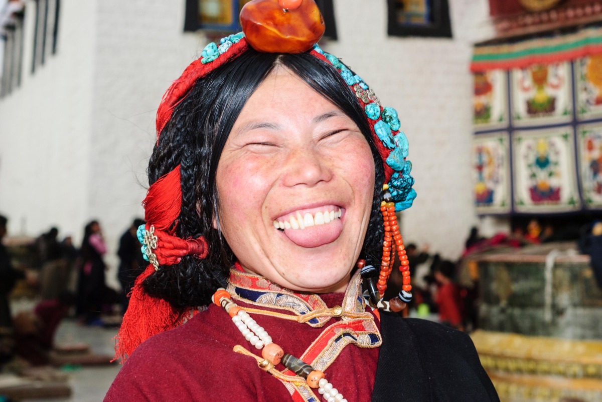 Tibet woman sticking out her tongue as a greeting