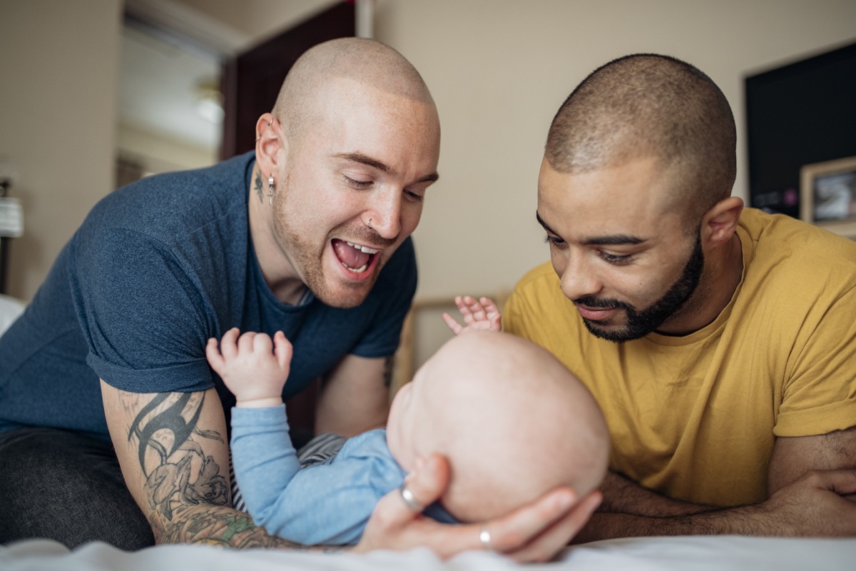 two dads playing with baby