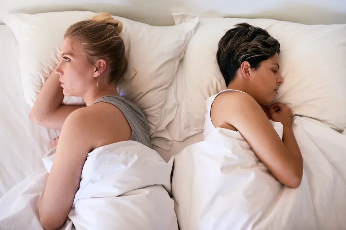 unhappy couple lying back to back