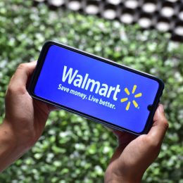 two hands holding a phone with the walmart app up on it