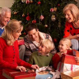 white grandparents, mother, father, and young daughter opening gifts