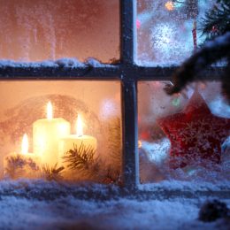 winter window has snow on sill with candles inside