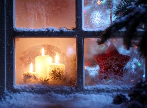 winter window has snow on sill with candles inside