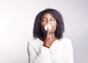 Black woman chewing gum and blowing a bubble