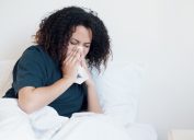 Woman sick and coughing in bed