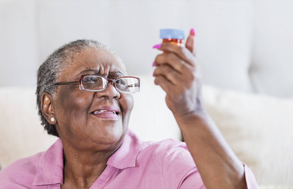 Senior African American woman struggling to read the label on a medicine