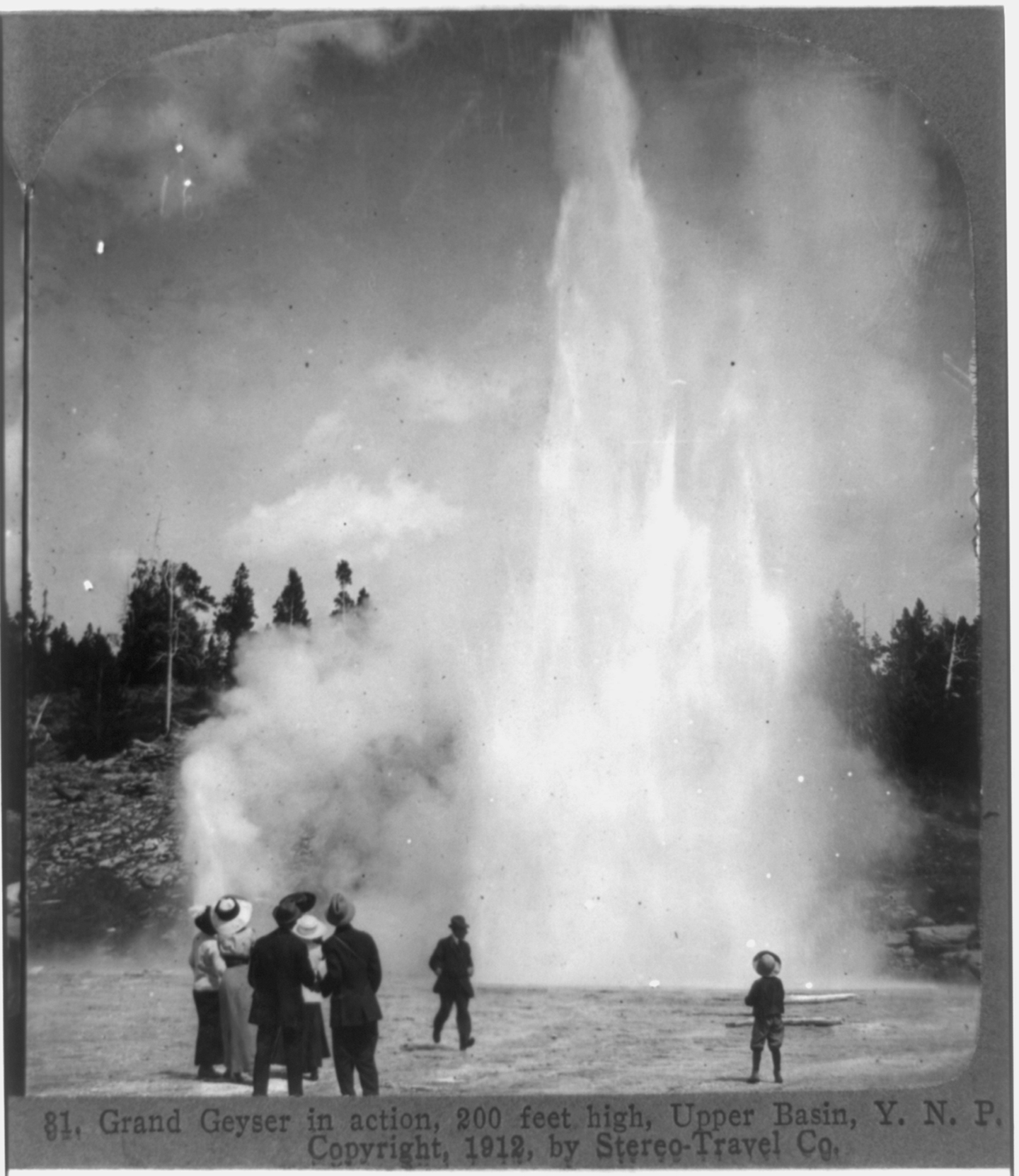 a group of onlookers watch a geyser erupt
