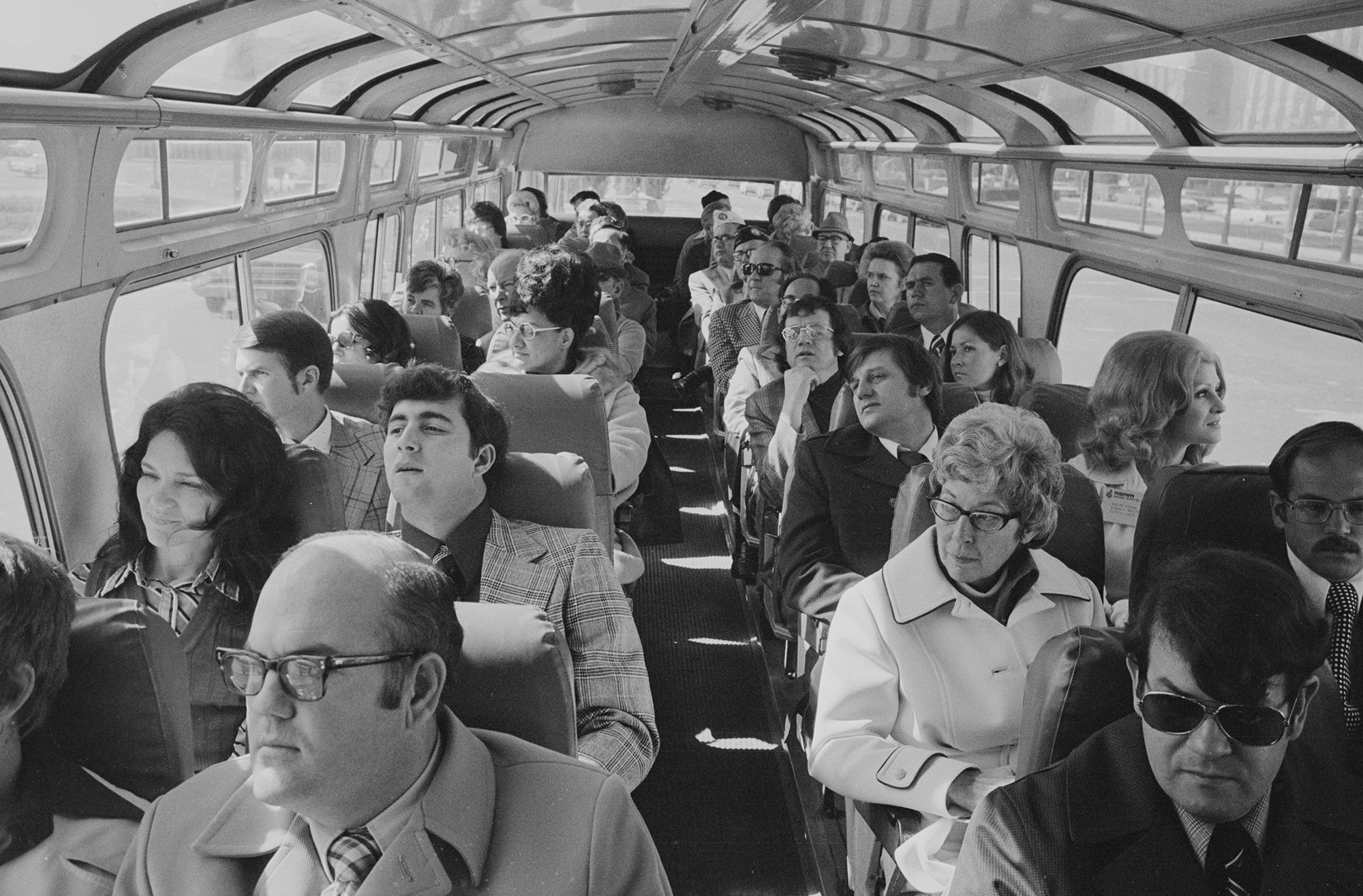 a group of people sit in a bus in the 1970s