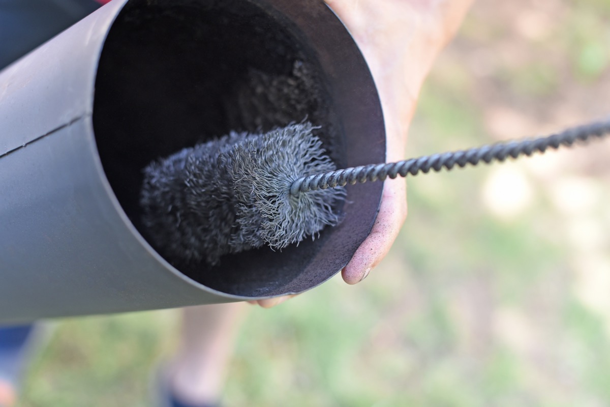 Brush cleaning a chimney pipe