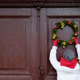 Person hanging Christmas wreath