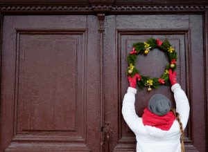 Person hanging Christmas wreath
