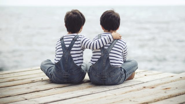 Twin brothers sitting on dock