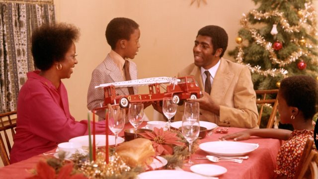 1970s AFRICAN AMERICAN FAMILY AT CHRISTMAS HOLIDAY DINNER TABLE FATHER MOTHER SON AND DAUGHTER