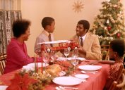 1970s AFRICAN AMERICAN FAMILY AT CHRISTMAS HOLIDAY DINNER TABLE FATHER MOTHER SON AND DAUGHTER