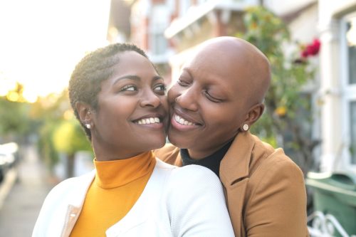 30-something black lesbian couple being affectionate outdoors