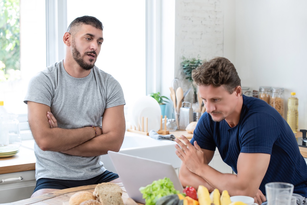 two white men standing in kitchen looking bored