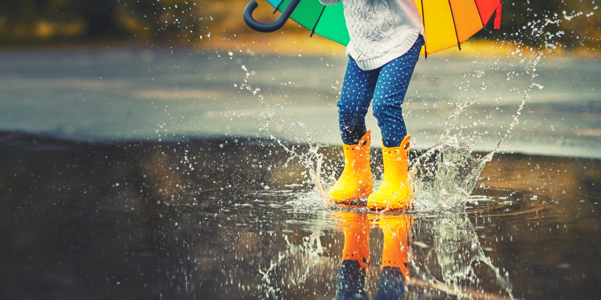 child jumping in puddle on a rainy day