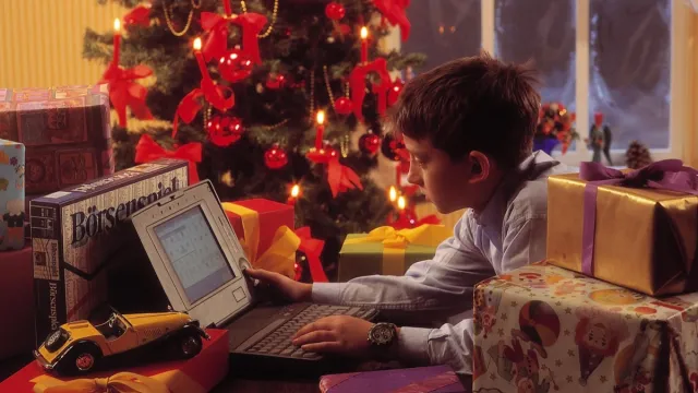 Boy playing with his new computer for Christmas in the 1990s