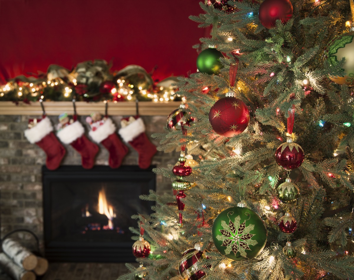 Christmas tree against a fireplace with stockings and copy space