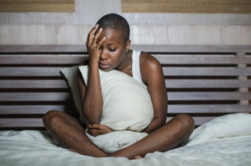 depressed woman sitting in bed