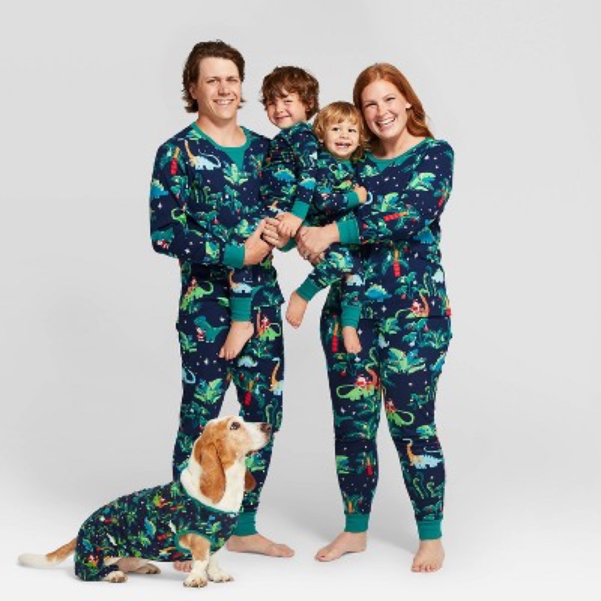white mother and father, two kids, and a dog in green dinosaur pajamas