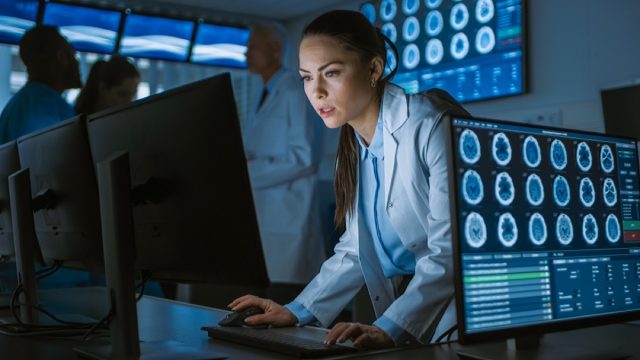 young female doctor in lab coat looks at scans