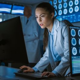 young female doctor in lab coat looks at scans