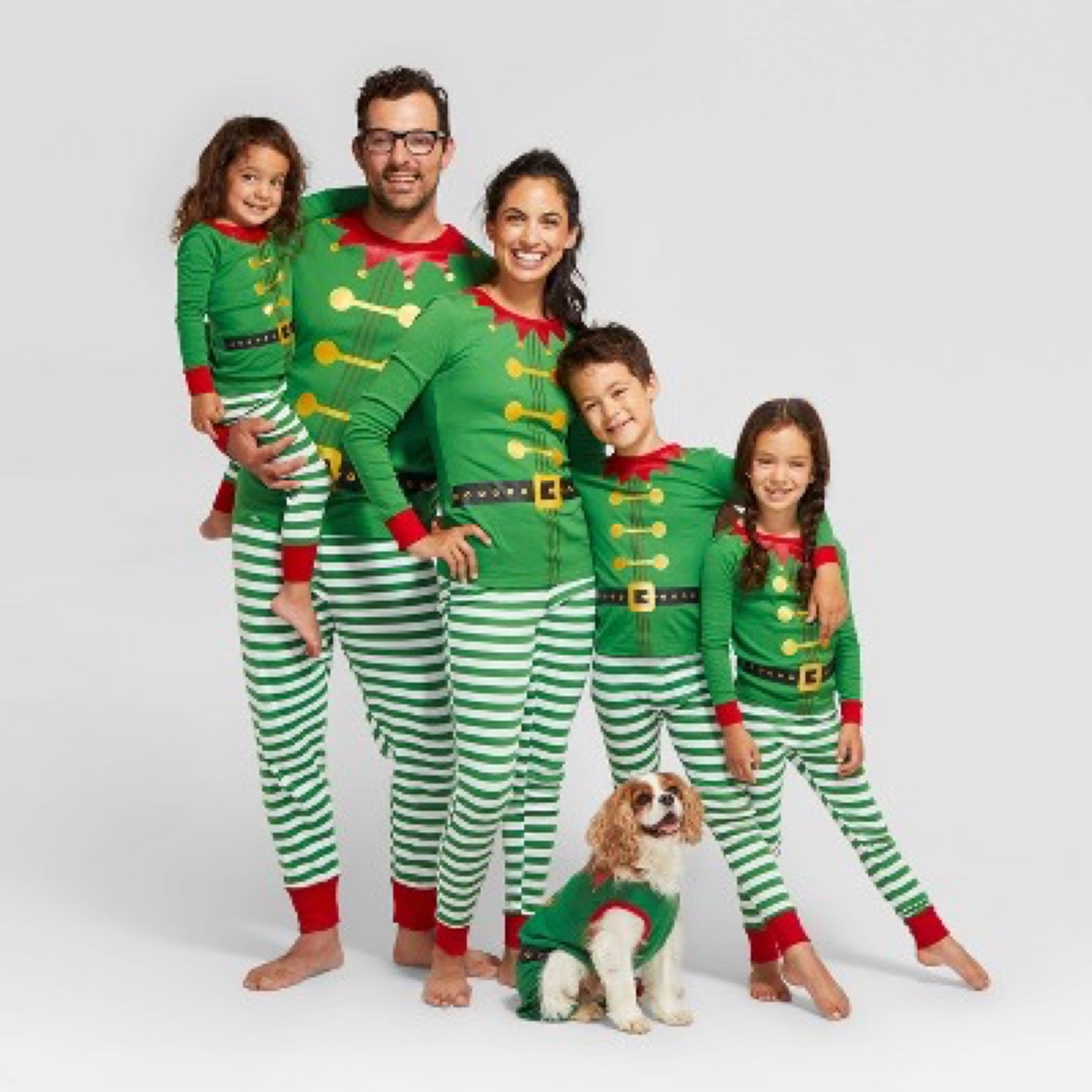 mother, father, three kids, and dog in green elf pajamas