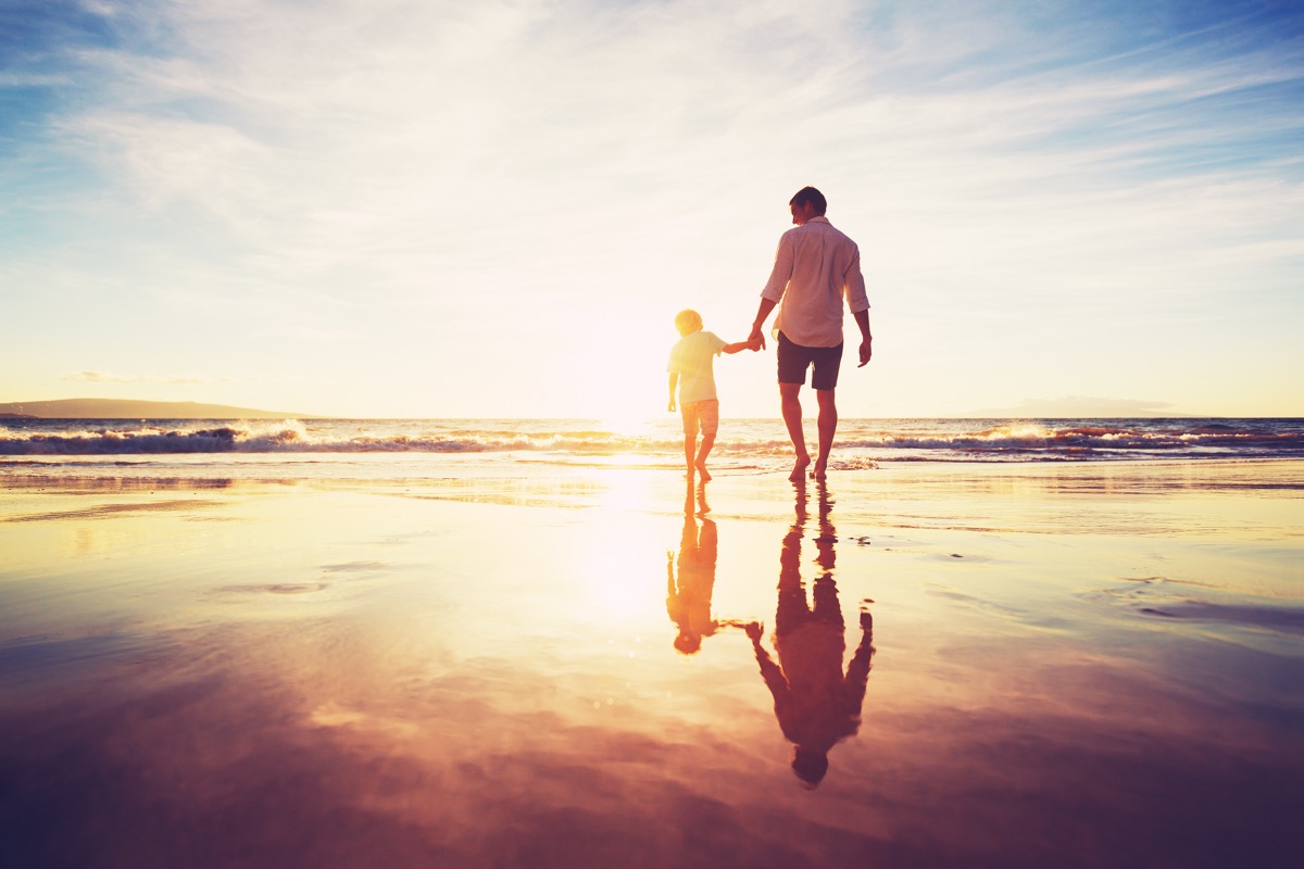 white father son walking on beach