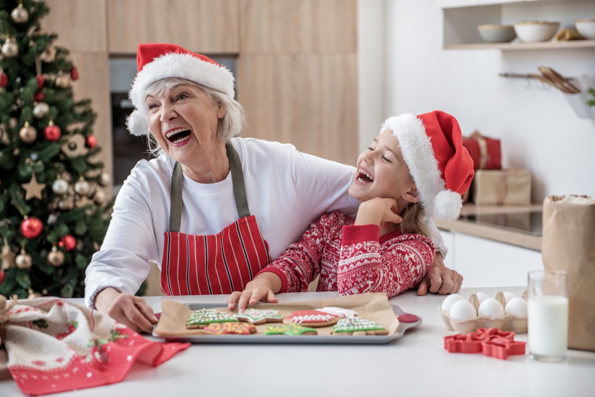 grandma and granddaughter making christmas cookies and laughing