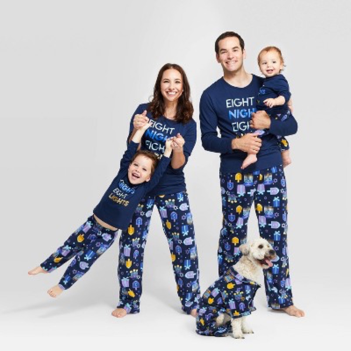 white mother, father, two kids, and dog in hanukkah pajamas