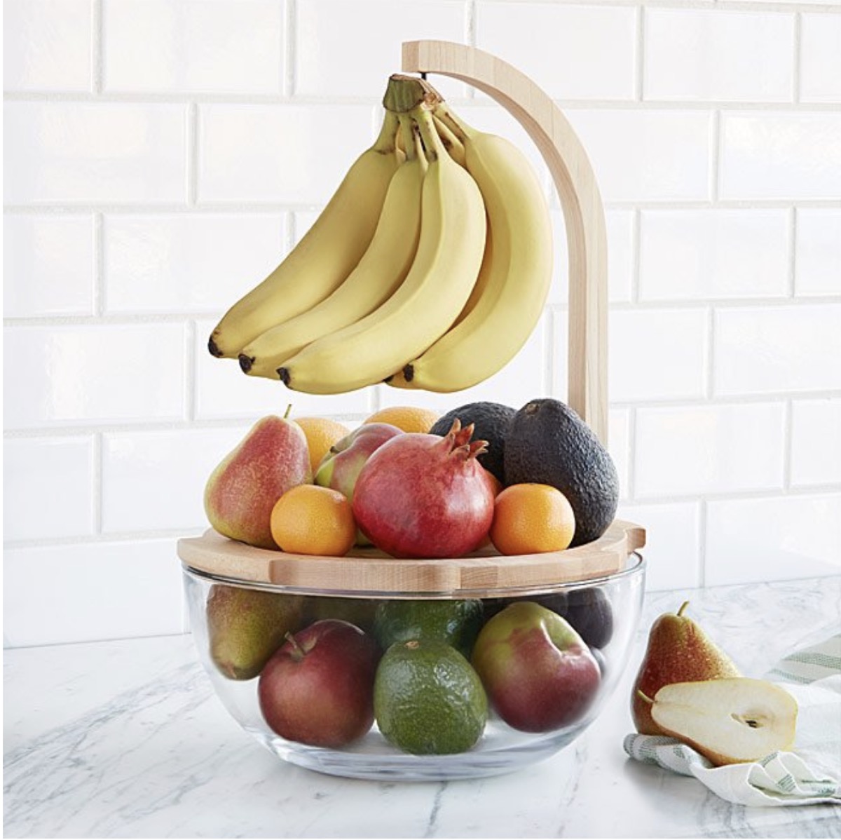 bowl of fruit with wooden lid and hanging bunch of bananas