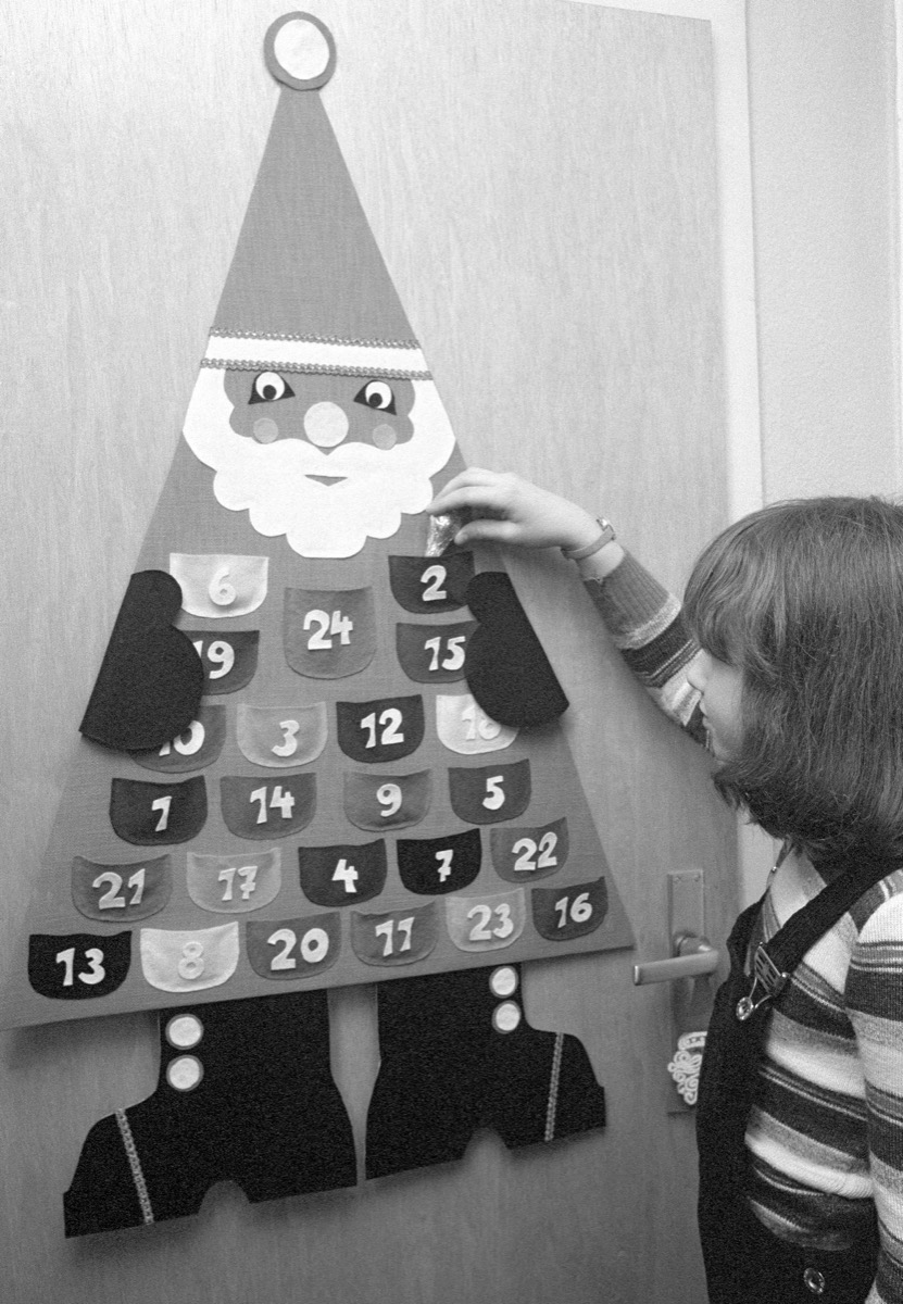 Seventies, black and white photo, Christmas, Advent, little girl opens a window of the Advent calendar, aged 4 to 7 years, Babette