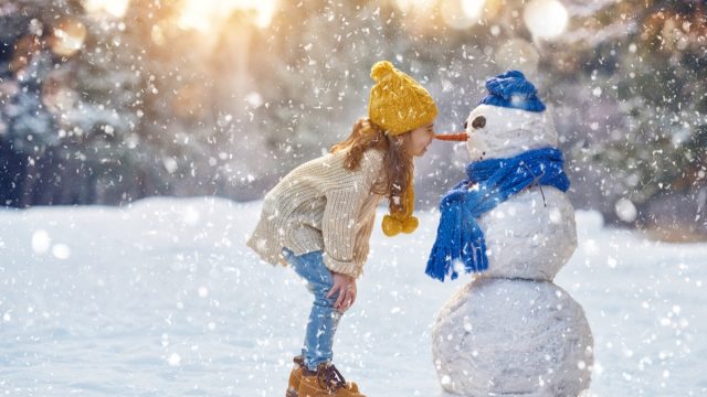 https://bestlifeonline.com/wp-content/uploads/sites/3/2019/12/little-girl-outside-in-winter-with-cnowman.jpg?quality=82&strip=1&resize=640%2C360