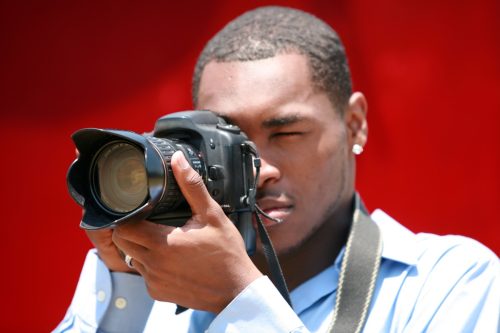 Black man taking photographs with a professional camera