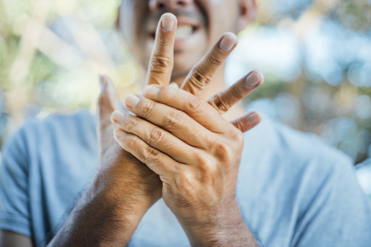 Man holding his thumb in pain