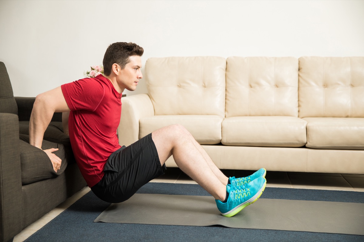 Man doing tricep dips on the couch