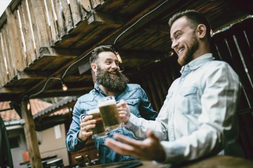 men laughing together over a beer